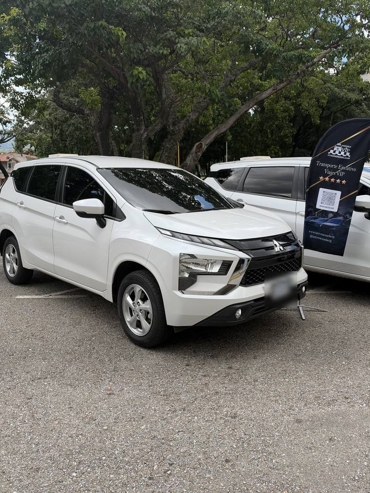 Mitsubishi Xpander blanca junto al pendón de Taxi Venezuela VIP
